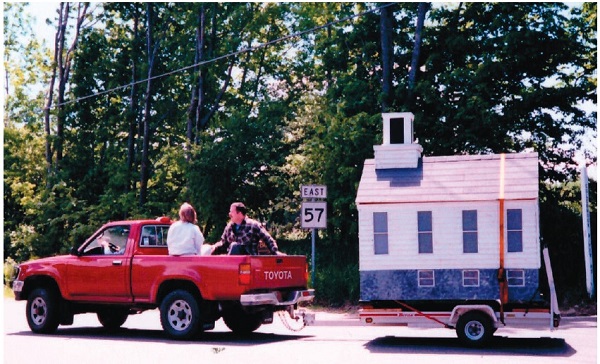 image of the mini Montville Church being towed by a pickup truck.