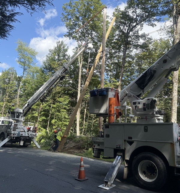 image of workers installing a telephone pole.